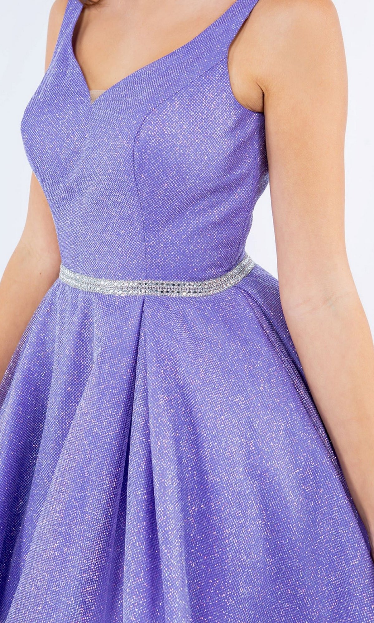 A person wearing the Short Glitter Princess Homecoming Dress 8047J—a sleeveless, shimmery lavender baby doll party dress with a V-neckline and a silver waist belt.